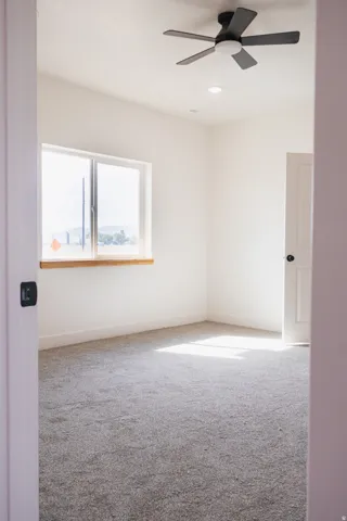 Recessed lighting, ceiling fan, wood window sill, white walls, and gray carpeting