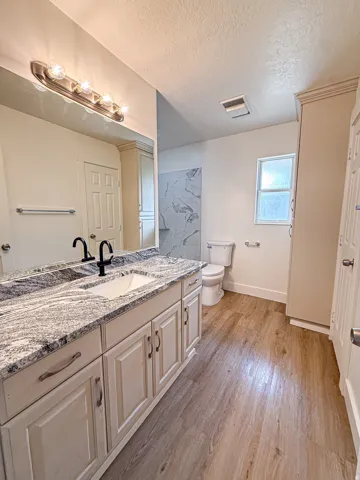 Dual vanity with undermount sinks, patterned stone countertop, and black fixtures