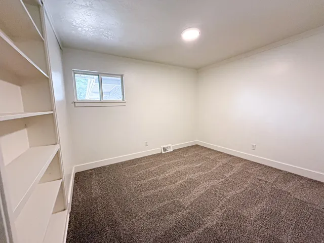 Recessed lighting, built-in shelving, white trim, and a window