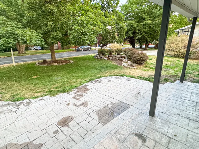 Stamped concrete patio with a stone retaining wall and mature landscaping
