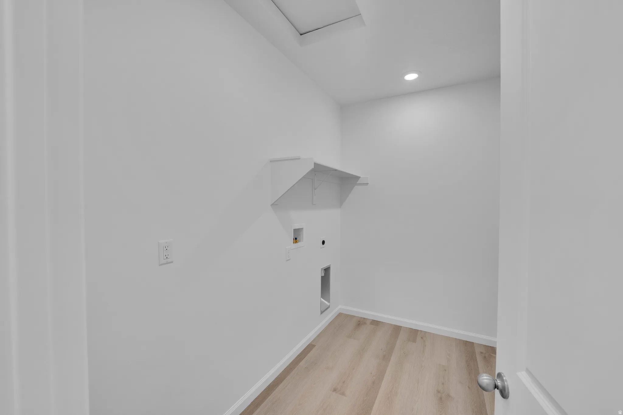 Recessed lighting, wood-finish flooring, built-in wall shelving, and utility hookups