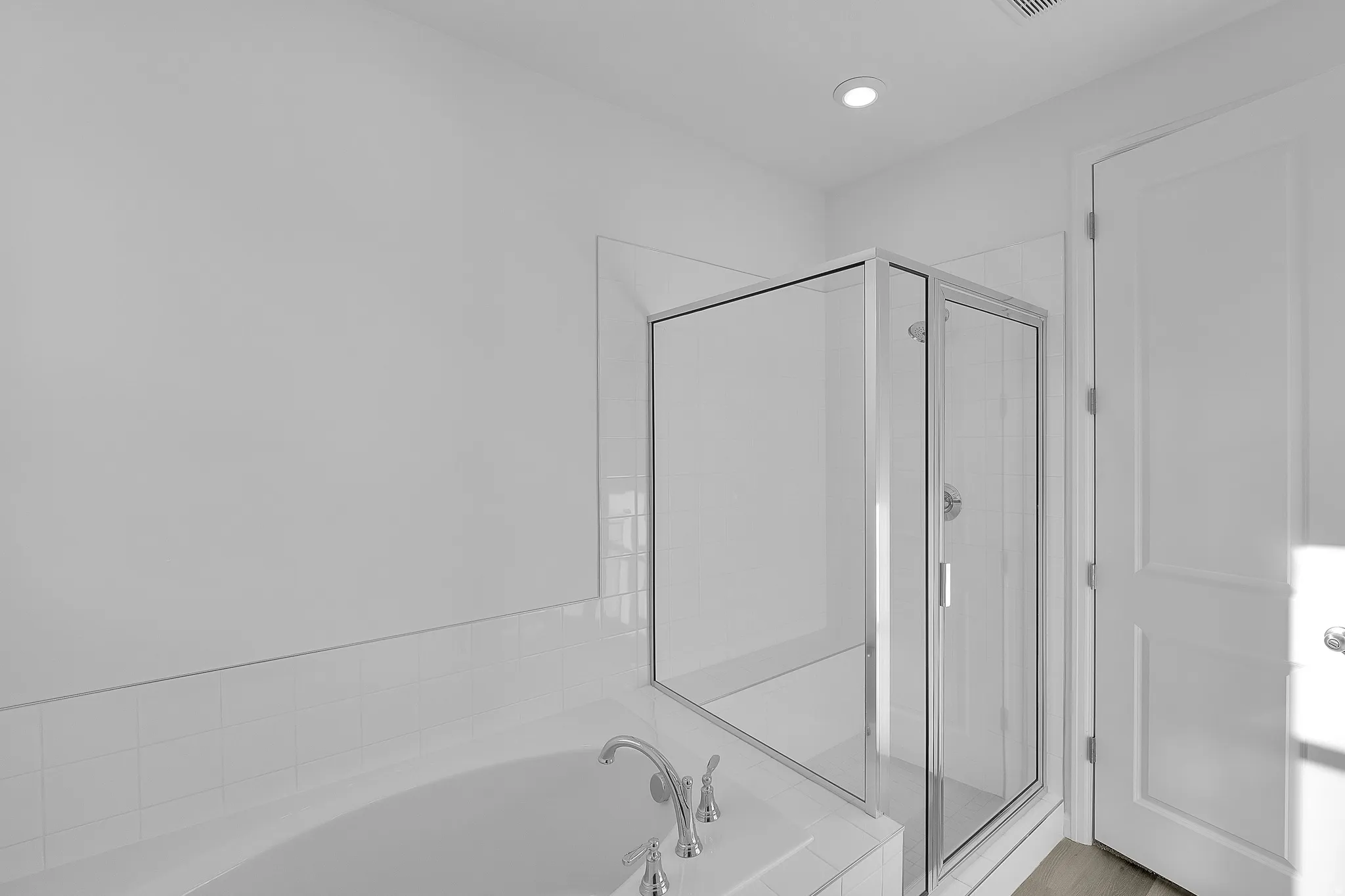 Soaking tub with deck-mounted faucet and adjacent glass-enclosed shower