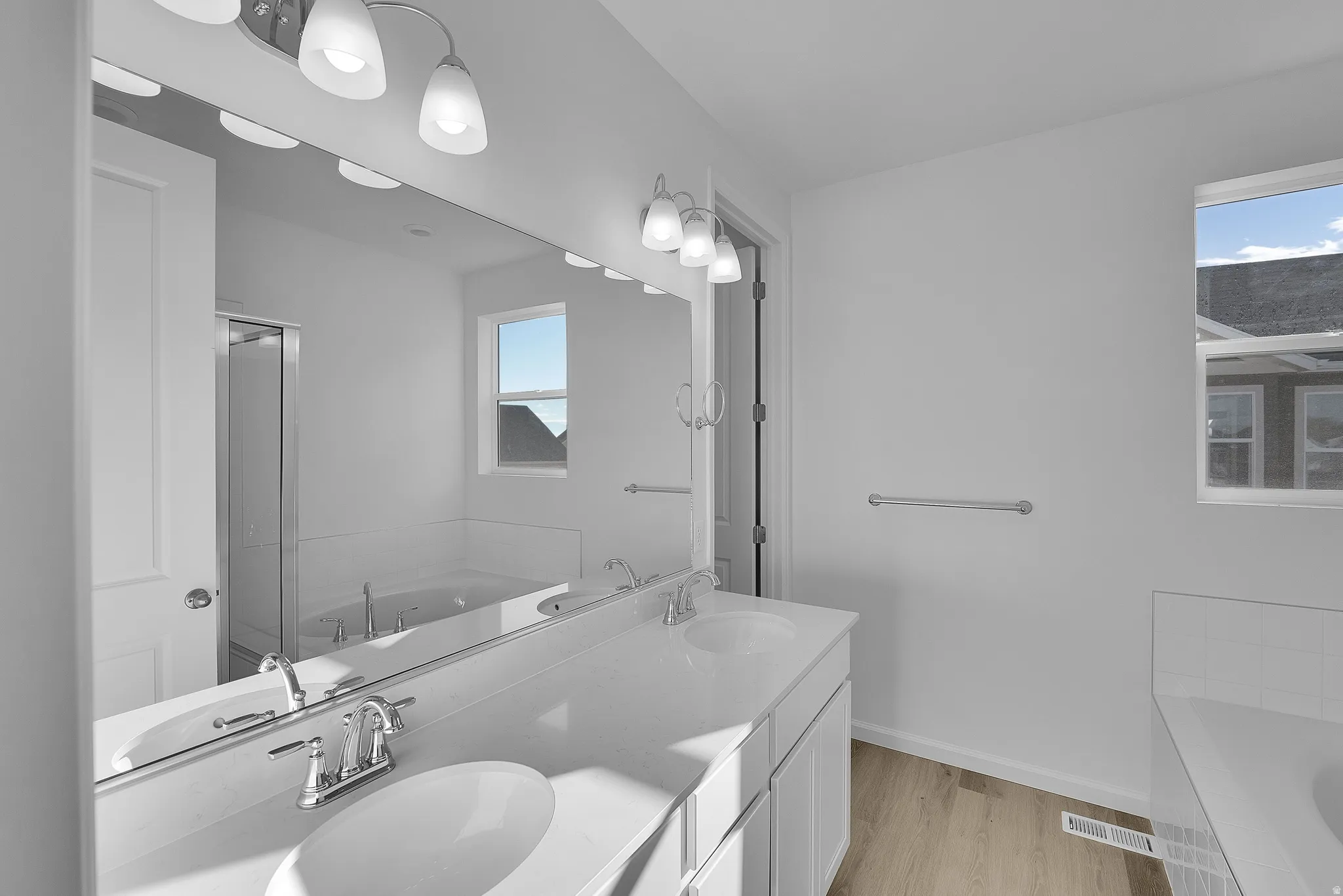 Dual vanity with undermount sinks, chrome fixtures, and white cabinetry