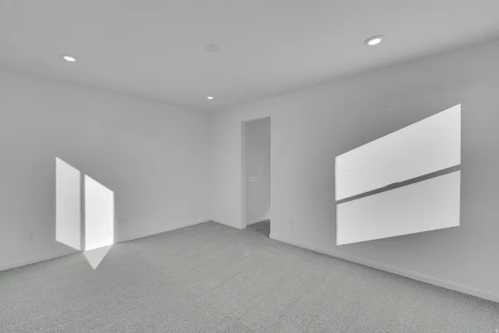 Recessed lighting with a light gray carpet and white walls