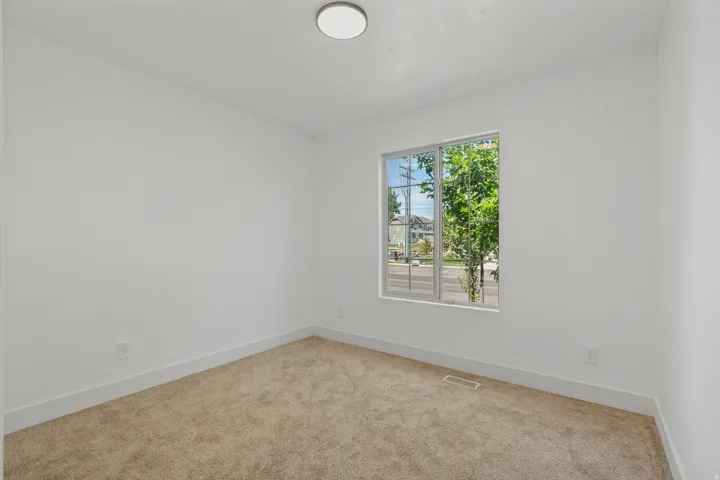 Neutral paint palette with carpeted flooring, a flush mount ceiling light, and a window with white trim