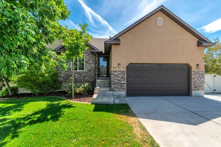 Exterior featuring stone accents, stucco siding, and an attached two-car garage