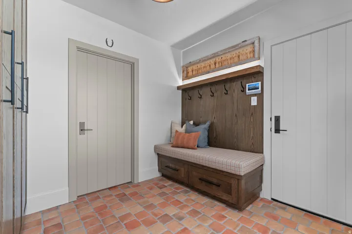 Built-in mudroom bench with storage drawers, wood paneling, and integrated coat hooks