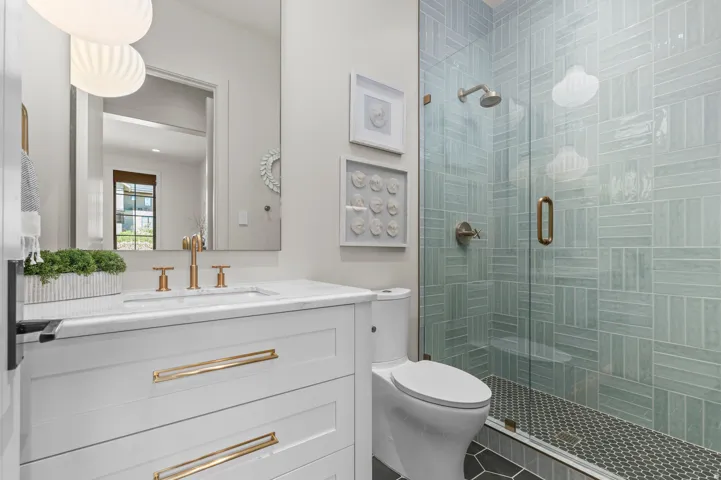 White vanity with brass hardware, marble-finish countertop, and a rectangular undermount sink