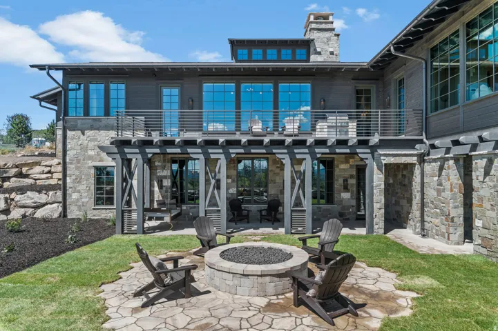 Stone veneer exterior with an upper-level balcony featuring metal railings