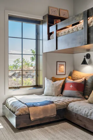 Built-in L-shaped seating, integrated wall-mounted bunk bed, built-in shelving, black wall sconce, and large grid-pattern window