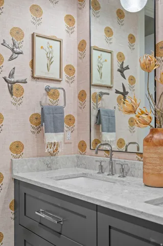 Dual vanity with integrated sinks, gray shaker-style cabinetry, and polished chrome fixtures