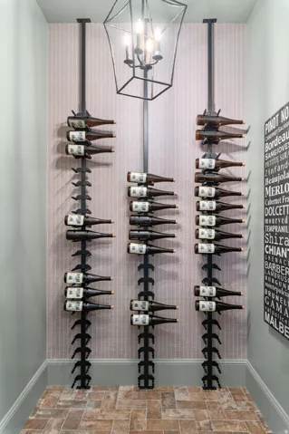 Specialized wine storage featuring three vertical racks, a geometric pendant light fixture, and patterned wall covering