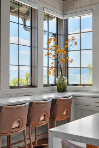 Corner window seating with a light-toned countertop, subway tile backsplash, and built-in power outlets
