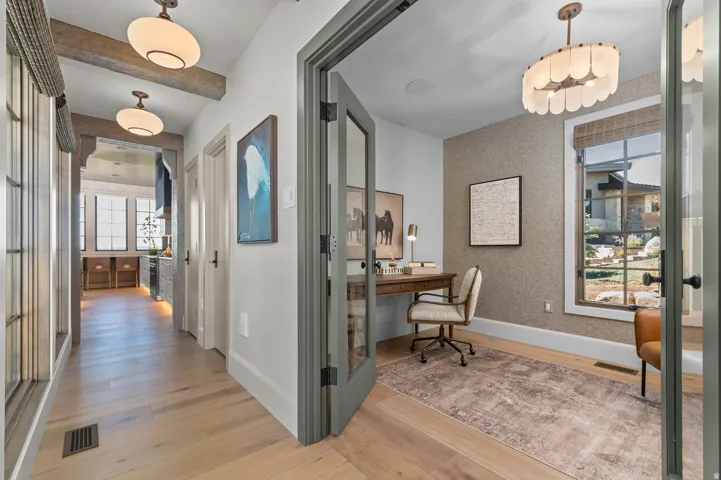 Hardwood flooring, painted French doors, textured wall covering, and a contemporary chandelier