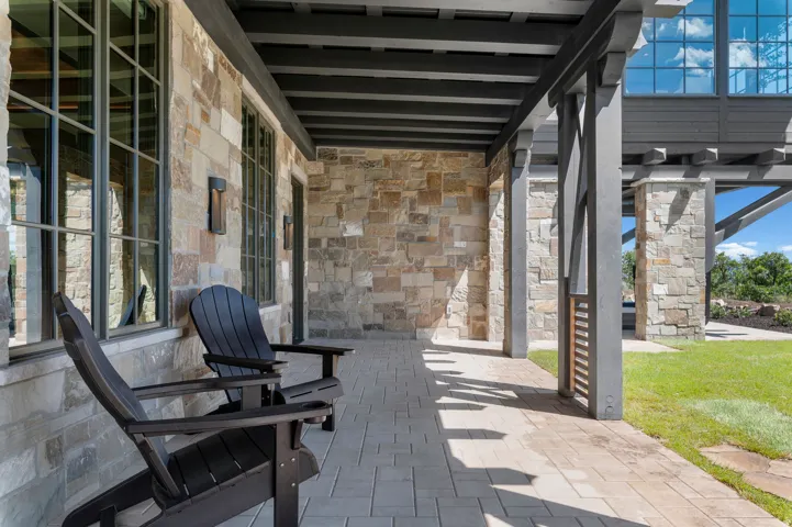 Stone exterior with grid-patterned windows and exterior lighting