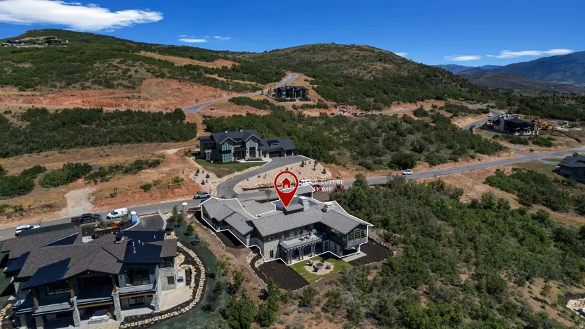 Expansive property featuring a multi-level residence with a gray exterior, a shingled roof, and an established lawn area