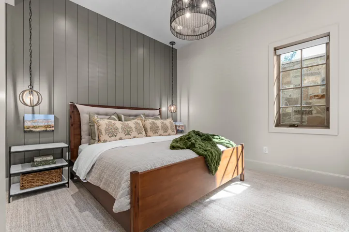 Board and batten accent wall, recessed lighting, textile drum pendant light, single window with wood trim, and light-colored carpeting