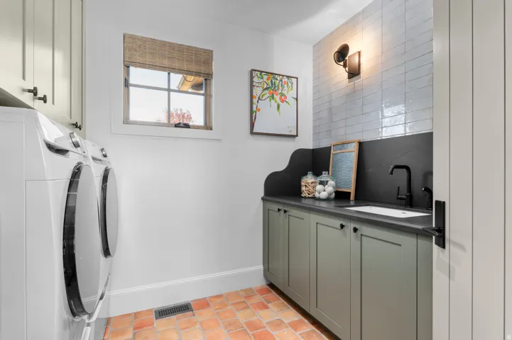 Terracotta tile flooring, built-in cabinetry with matte black hardware, integrated sink with a black gooseneck faucet, and white subway tile backsplash