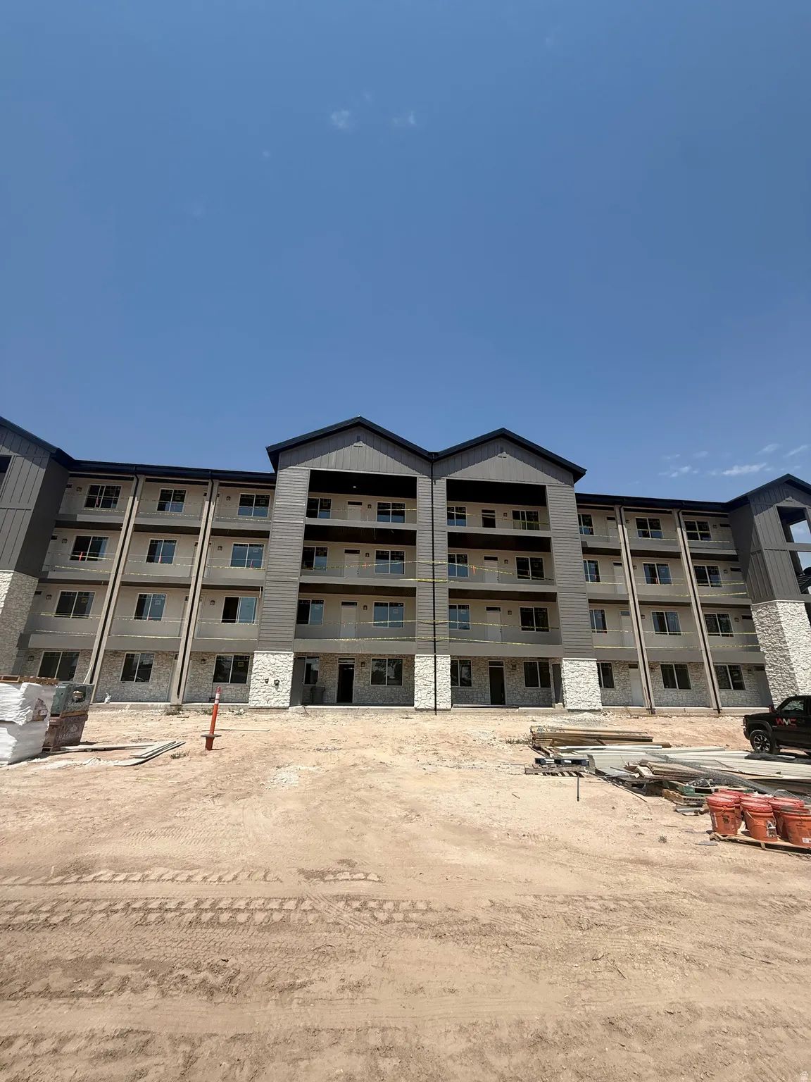 Multi-story building featuring a facade of horizontal siding and stone accents
