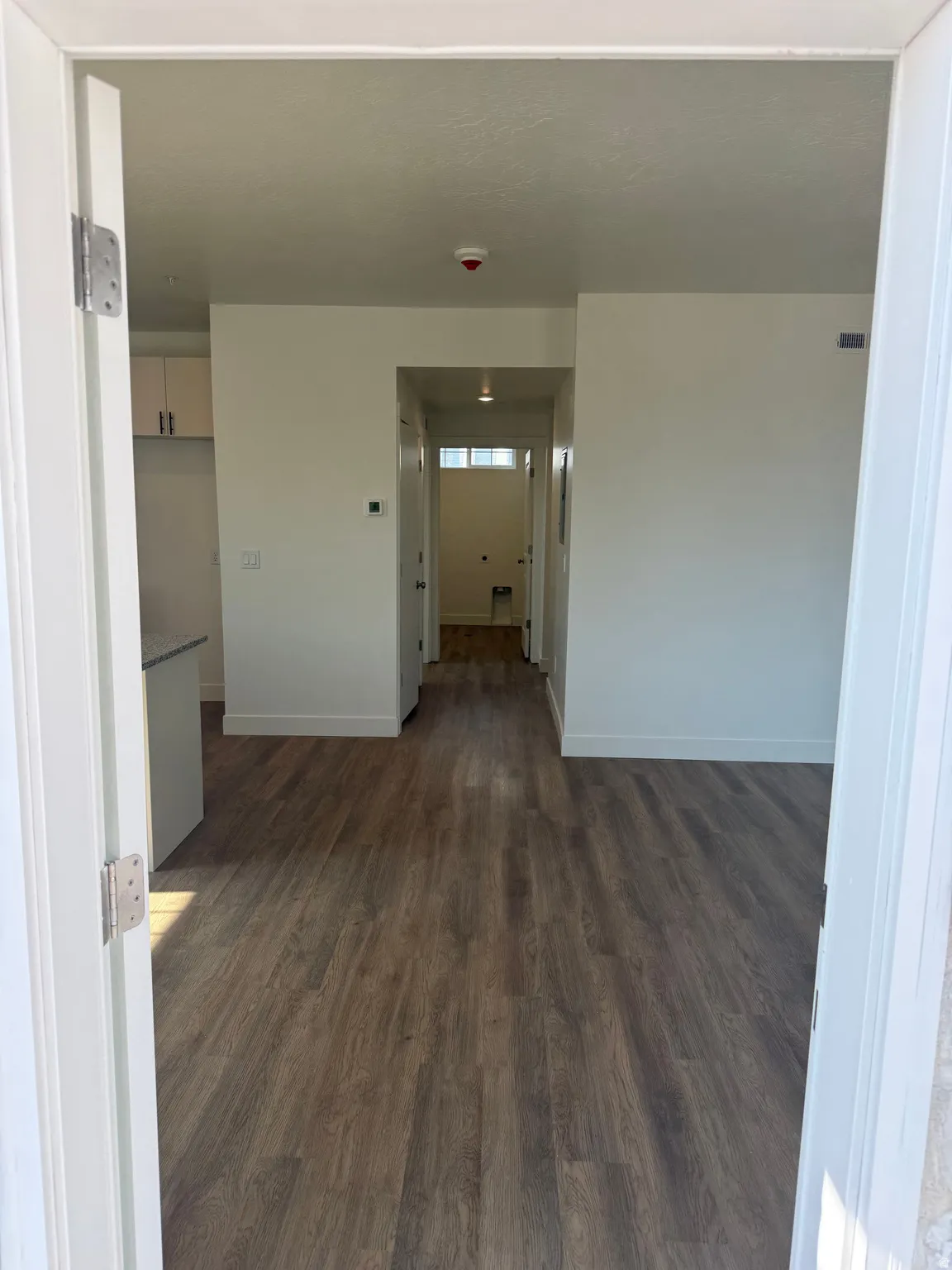 Wood-finish flooring throughout, white walls, and recessed lighting