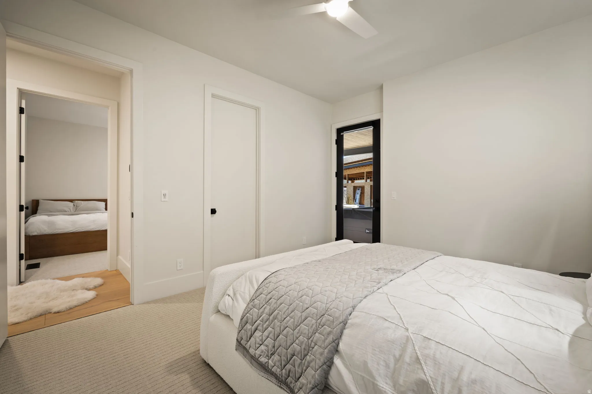 Recessed lighting, ceiling fan, carpet flooring, flat panel interior doors, and a black-framed exterior door