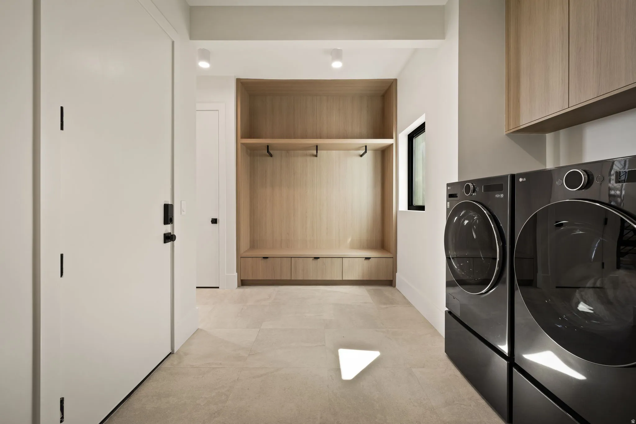 Built-in wood-finish cabinetry, integrated bench seating, and light-toned tile flooring