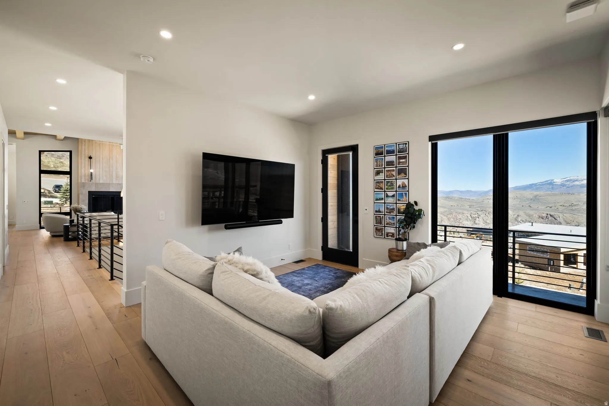 Wood-finish flooring, recessed lighting, and a wall-mounted television
