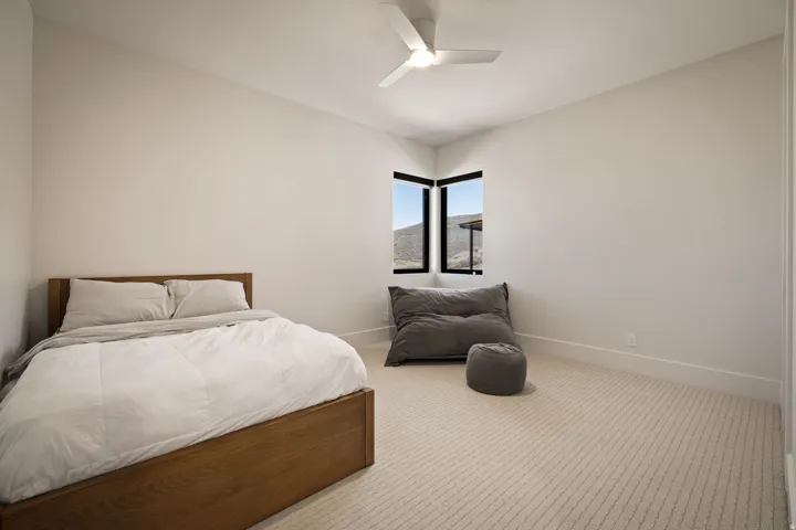 Corner windows with black frames and a ceiling fan