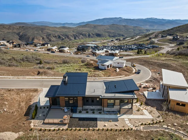 Modern architectural design with a dark metal roof and light flat roof sections