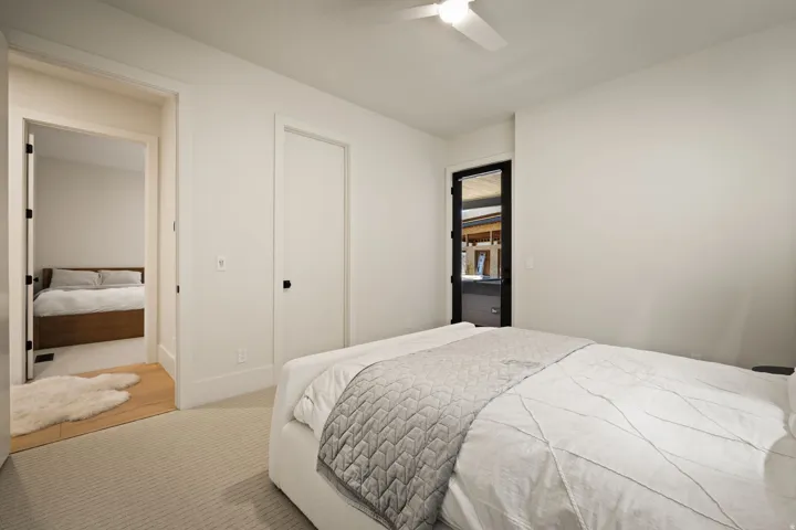 Recessed lighting, ceiling fan, carpet flooring, flat panel interior doors, and a black-framed exterior door