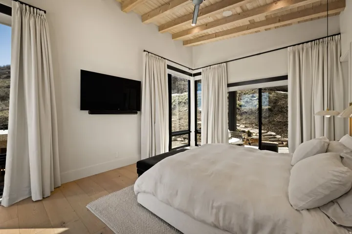 Vaulted wood-plank ceiling, wood-finish flooring, recessed lighting, and expansive glass doors