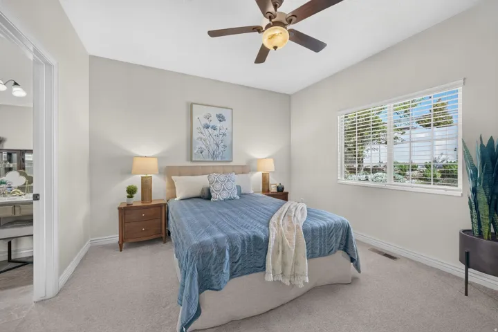 Carpeted room with a ceiling fan, white window blinds, and light-colored walls