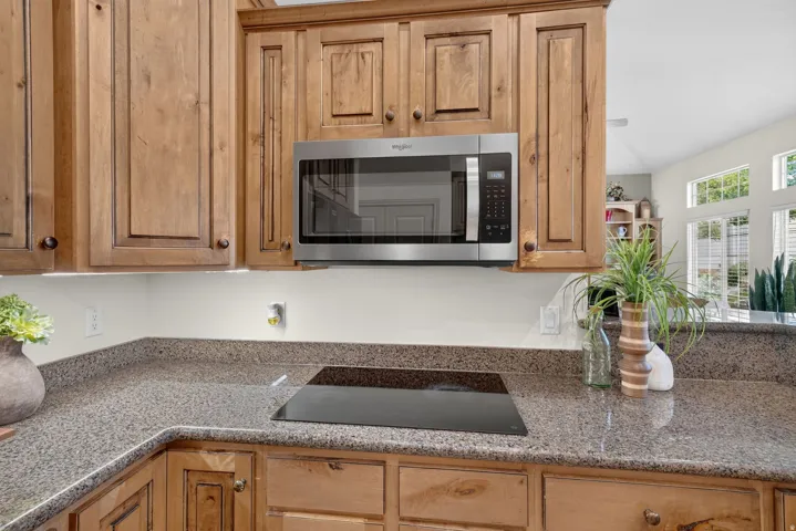 Wood-finish cabinetry paired with a stainless steel microwave