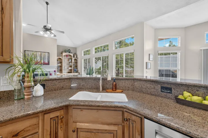 Corner sink with a dual basin, a stainless steel faucet, and granite countertops