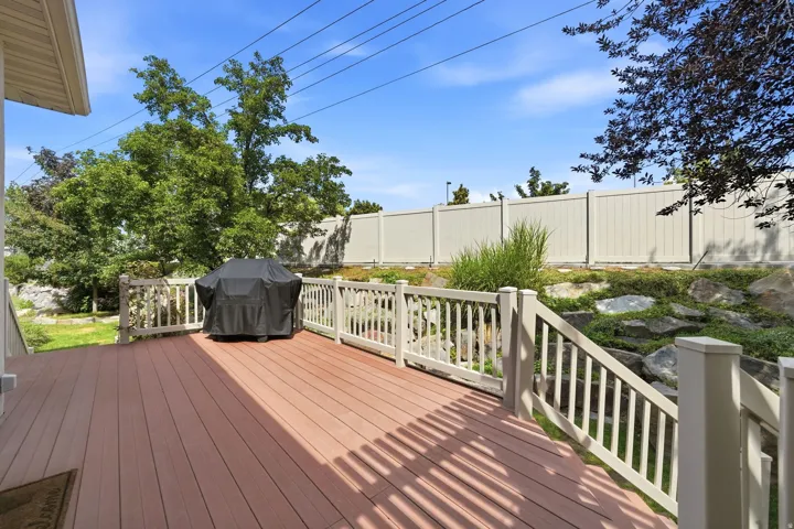 Expansive deck with wood-finish surface, white railing, and steps