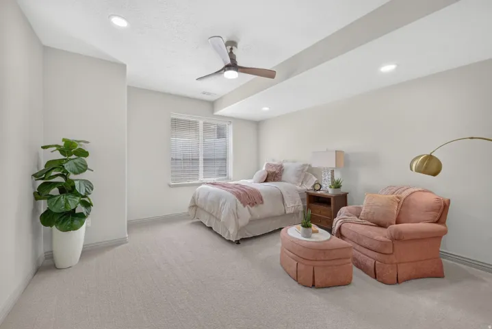 Recessed lighting throughout, ceiling fan, carpeted flooring, and a large window with blinds
