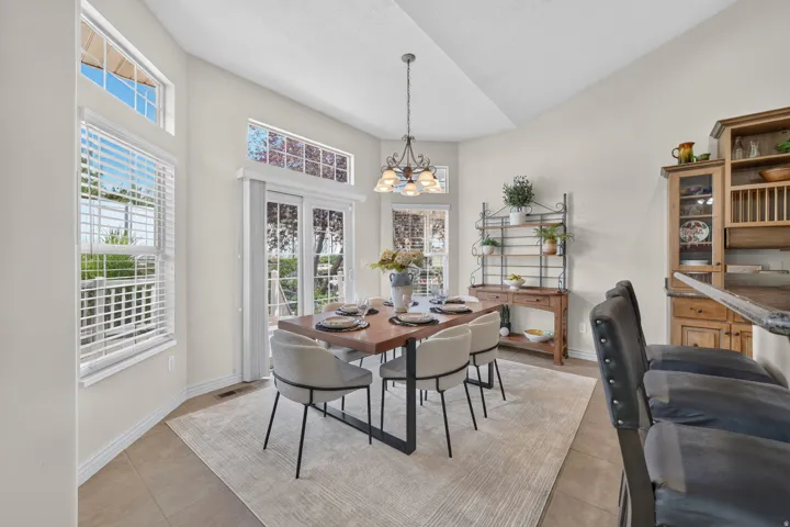 Vaulted ceilings, tile flooring, and large windows with integrated blinds