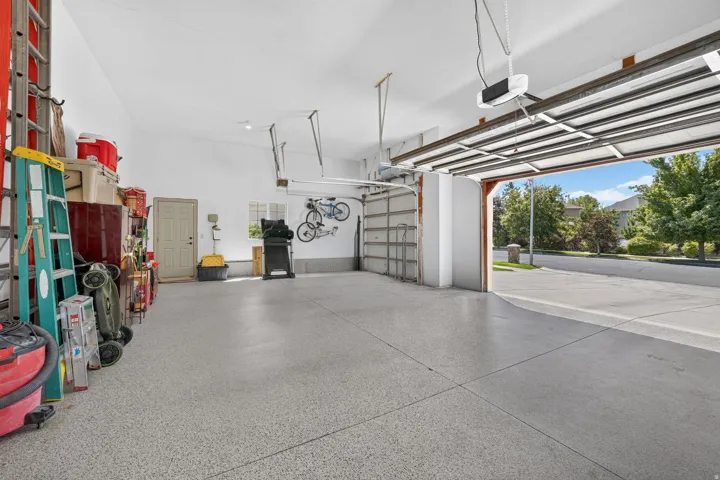 Spacious garage featuring a durable epoxy floor coating, white walls, and an overhead garage door