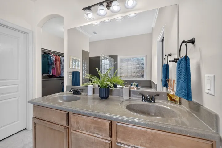 Double vanity with integrated sinks, dark bronze fixtures, and a large mirror