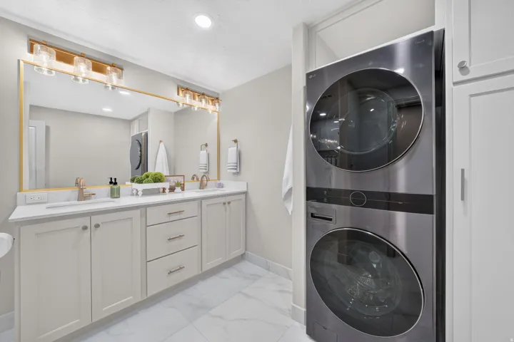 Dual vanity with white countertops, undermount sinks, and brushed gold fixtures