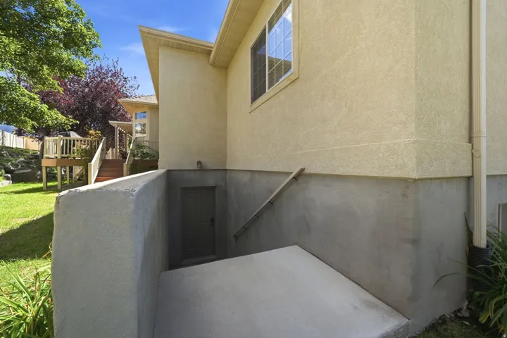Stucco exterior with a concrete foundation and a lower-level exterior entrance