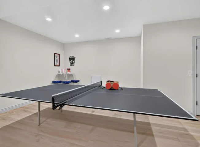 Recessed lighting illuminates neutral-toned walls and wood-finish flooring