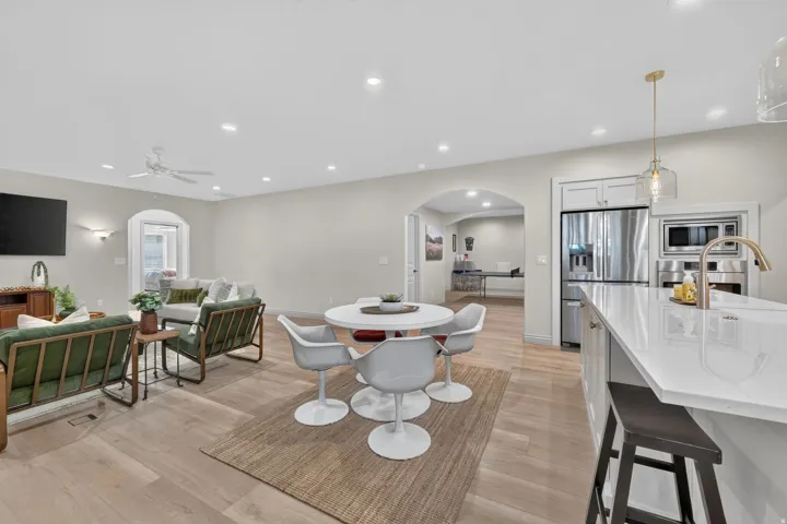 Open-concept living space with wood-finish flooring, recessed lighting, and an arched doorway