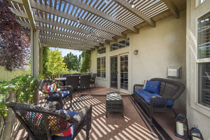 Spacious patio featuring a wood pergola, stucco exterior, and double glass doors