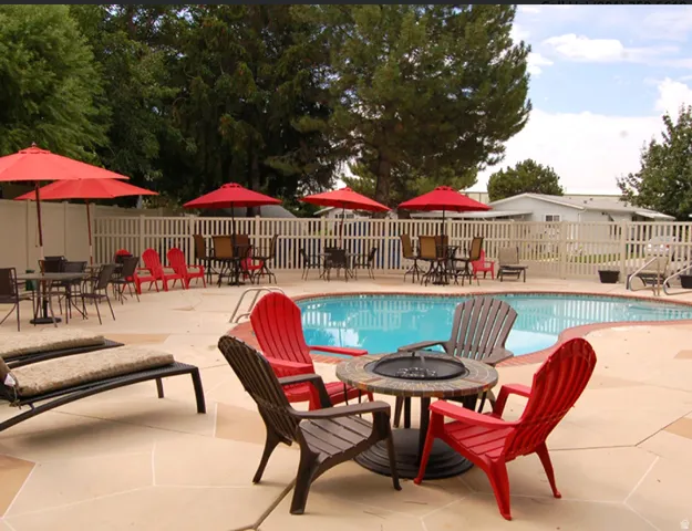 Swimming pool with a surrounding patio featuring a fire pit table