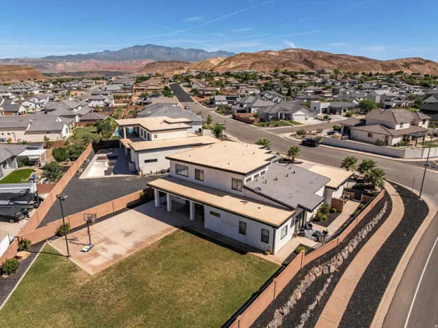 Contemporary architecture with varied rooflines, covered patio, and a dedicated concrete sports court