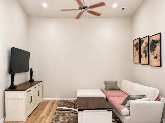 Recessed lighting with a ceiling fan, light-toned walls, and wood-finish laminate flooring