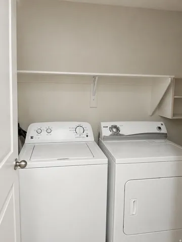 Laundry area with built-in shelving and white appliances. Brand New Never used Dryer ready to install located in garage