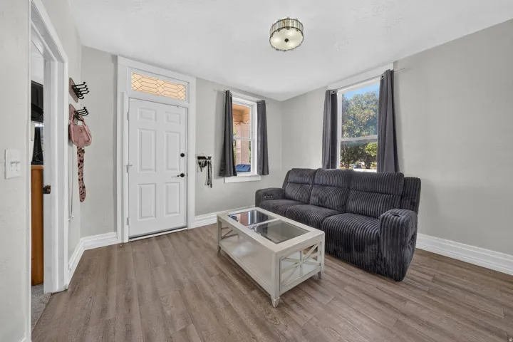 Wood-finish flooring, crisp white trim, and a decorative transom window above the entry door