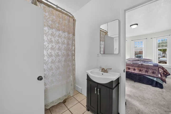 Dark wood-finish vanity with an integrated sink, brushed nickel faucet, and rectangular wall mirror